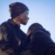 A tender moment between a young couple in Nairobi, reflecting love and warmth under a clear blue sky.
